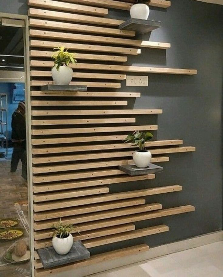 Pared decorada con listones de madera de diferente longitud